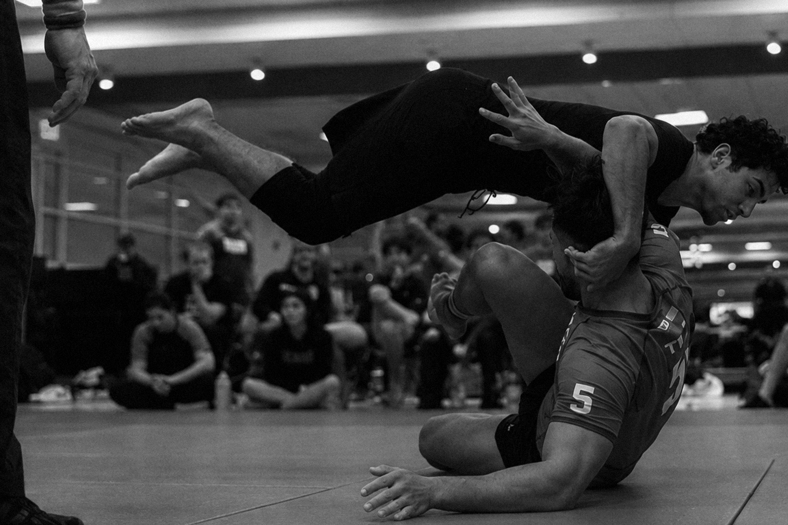 Collegiate jiu-jitsu athlete competing on the mat